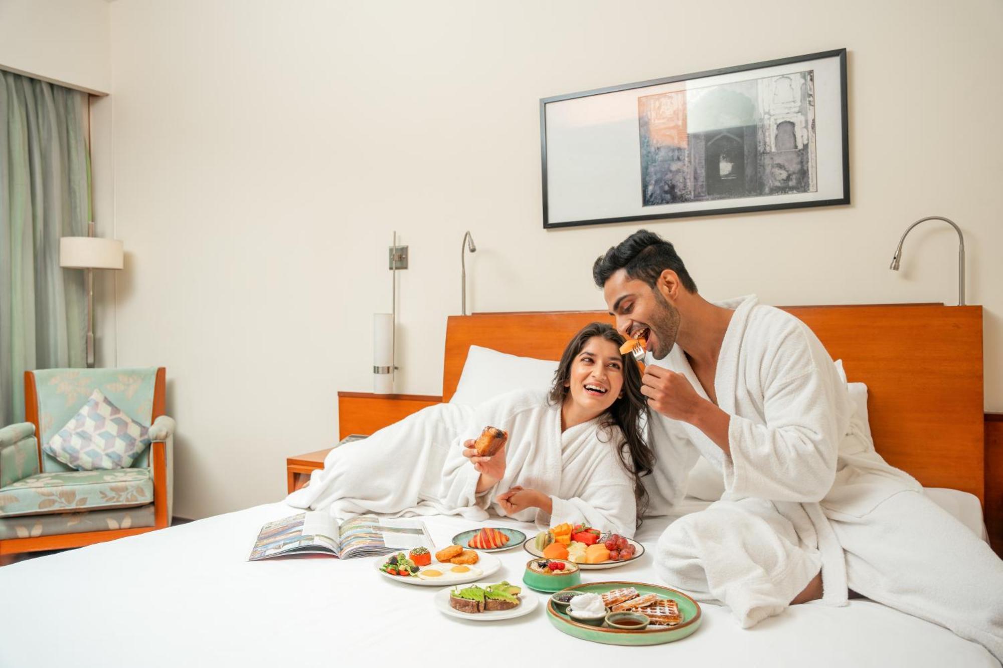 Hyatt Pune Eksteriør billede A couple eating breakfast in bed